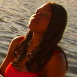 en person med en rød skjorte og en rød skjorte med en vannmasse bak