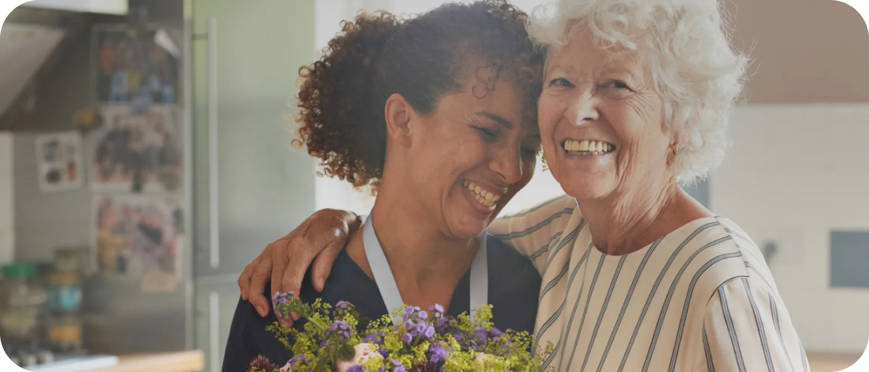 " Two women smile at each other, reflecting the importance of compassionate care in peristomal skin health."