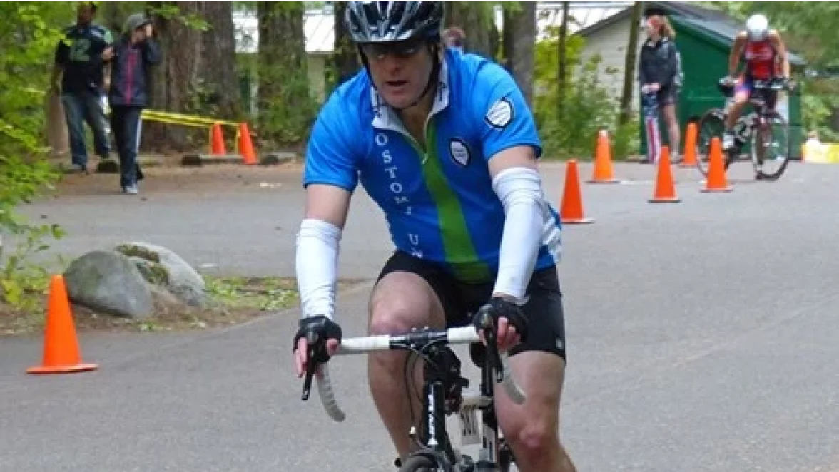 A man with an ostomy enjoying his cycling journey during his triathlon.